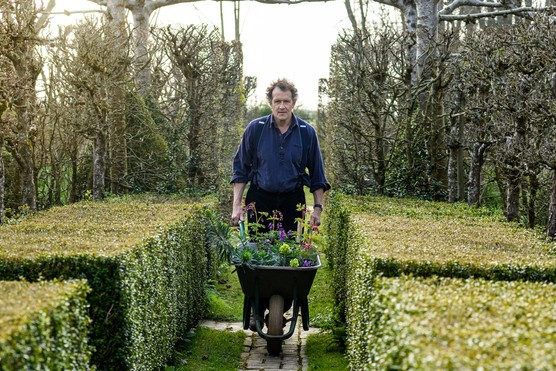 Monty pushing a wheelbarrow of plants for the cottage garden Monty pushing a wheelbarrow of plants for the cottage garden